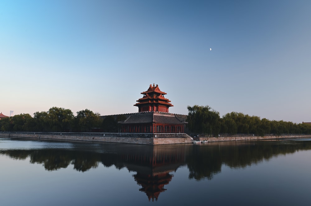 brown and black temple near body of water during daytime