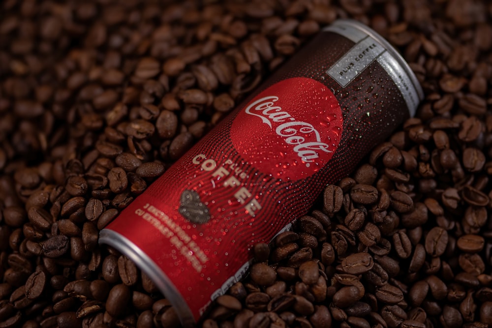 red and silver can on brown coffee beans