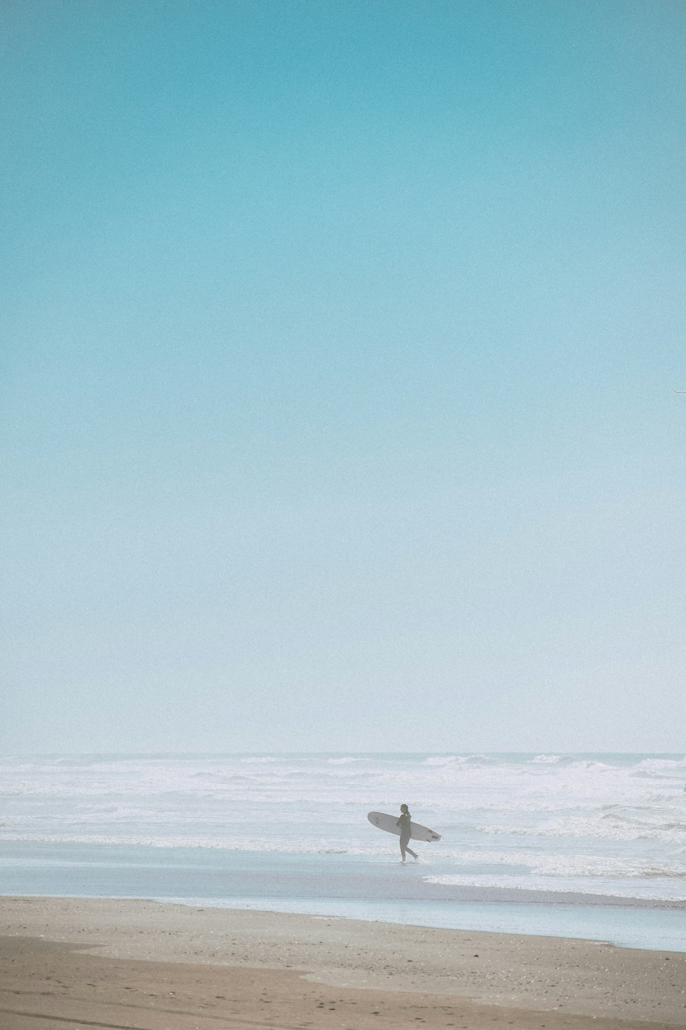 person in white shirt and black pants standing on white snow covered ground during daytime