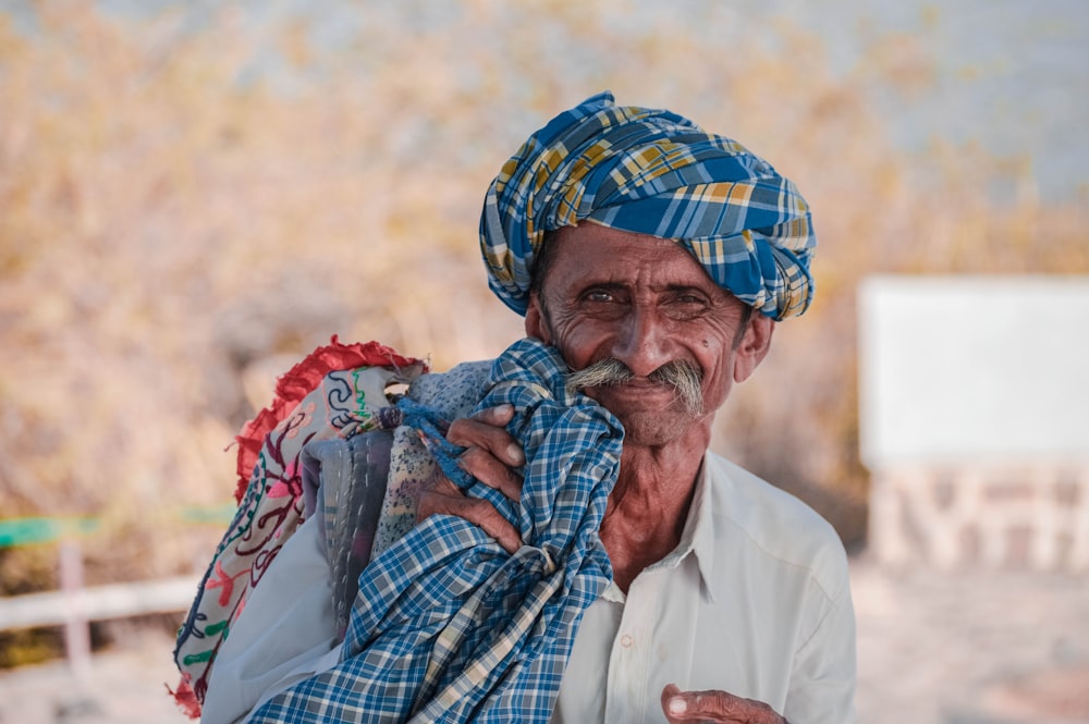 man in white dress shirt with blue and white plaid scarf