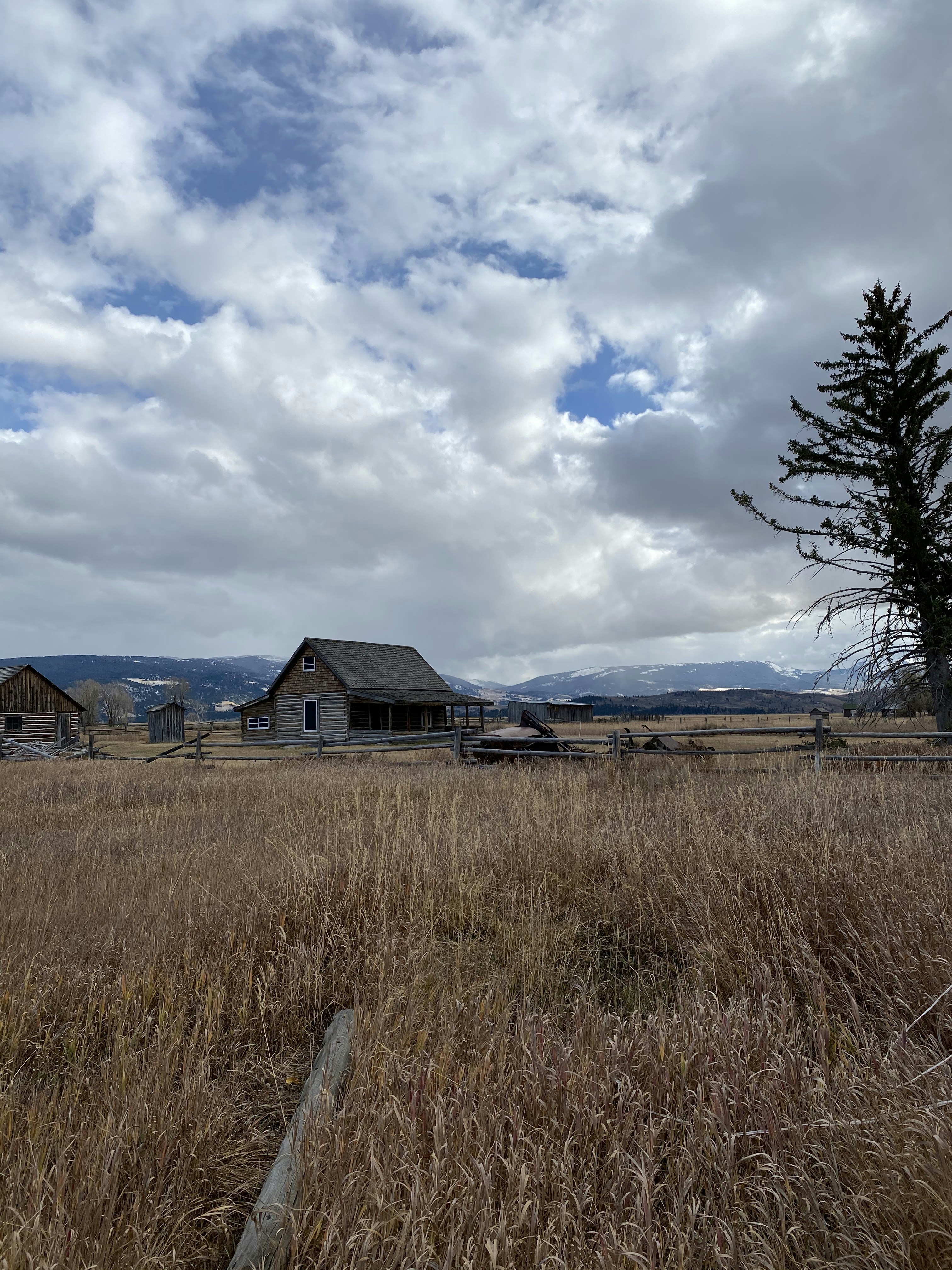 Brown wooden house near green grass field under white clouds and blue ...