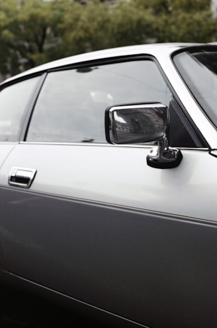 Close-up of a shiny car door with a perfectly repaired dent, reflecting the San Antonio skyline.