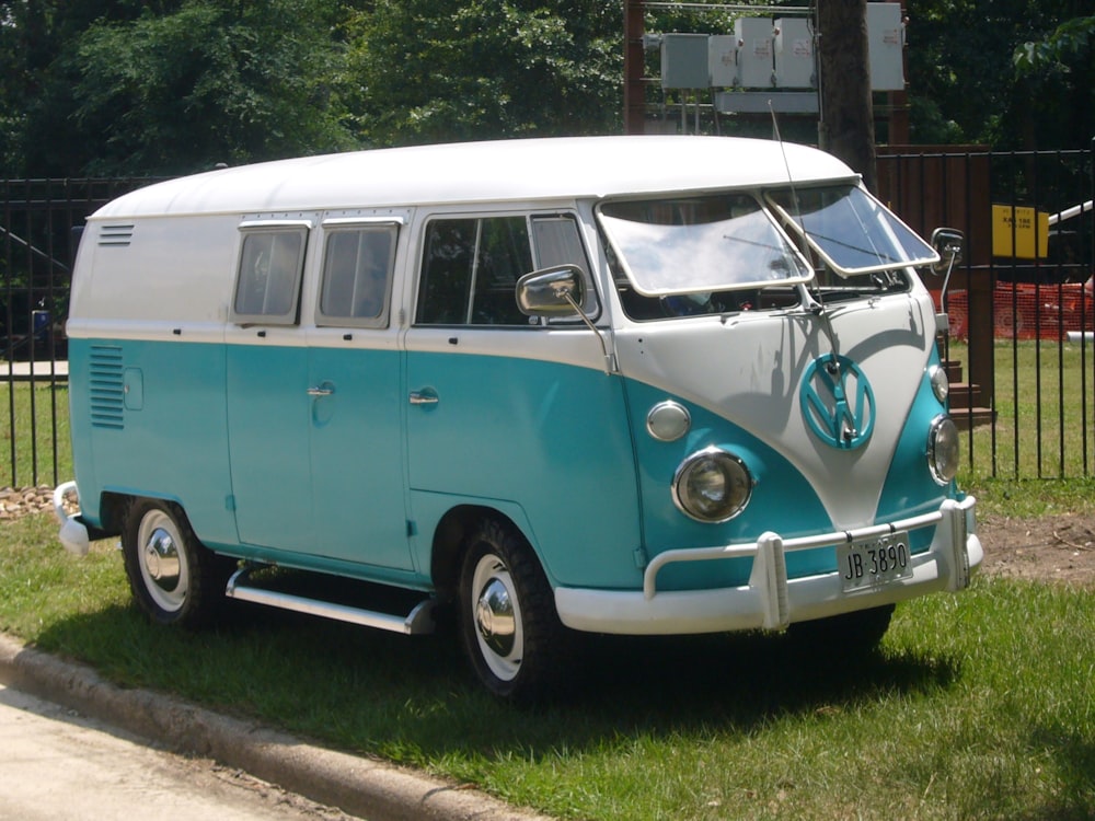 blue and white volkswagen t-2 van parked on the side of the road during daytime