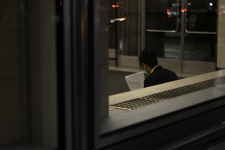 A professional reviewing detailed policy documents in an office setting.
