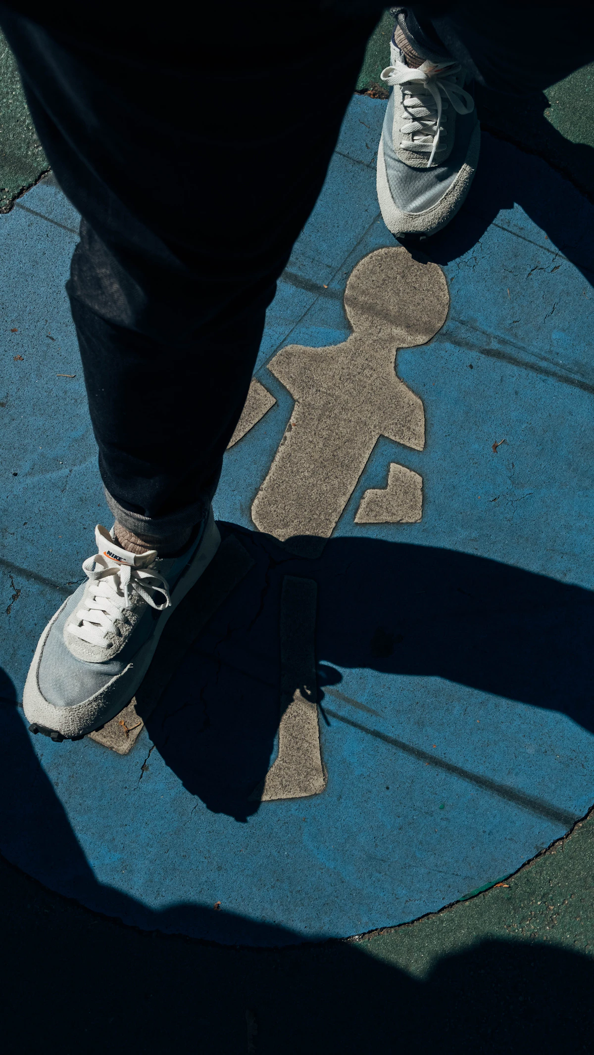 Pessoa com tênis esportivo caminhando em calçada urbana, lembrando calçado adequado e atenção ao entorno