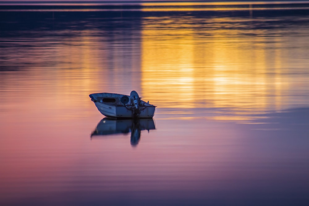 man riding on boat on sea during sunset