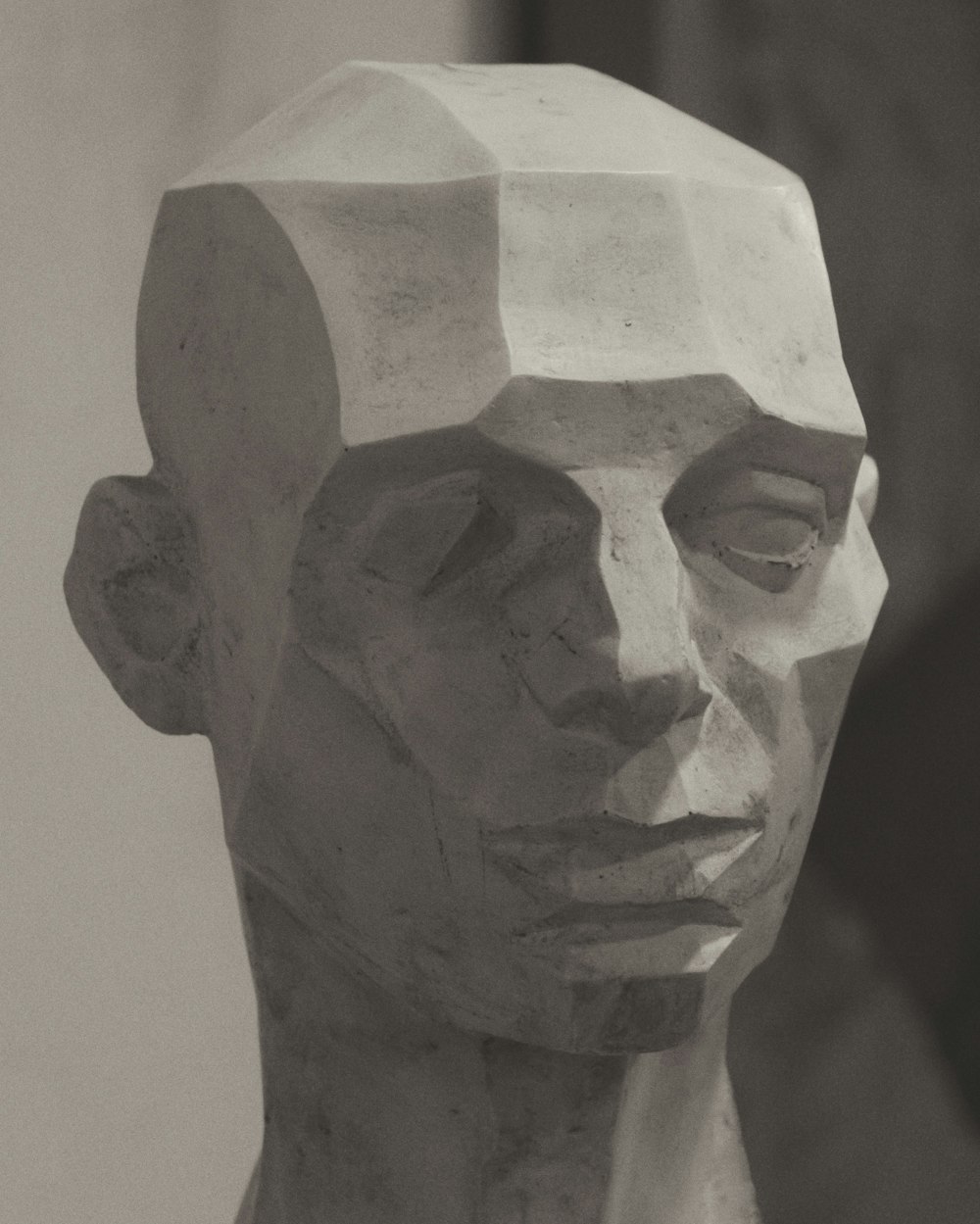 busto de cara de hormigón gris sobre superficie blanca