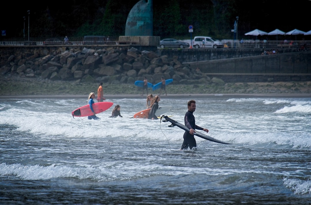 2 men riding on red kayak on body of water during daytime
