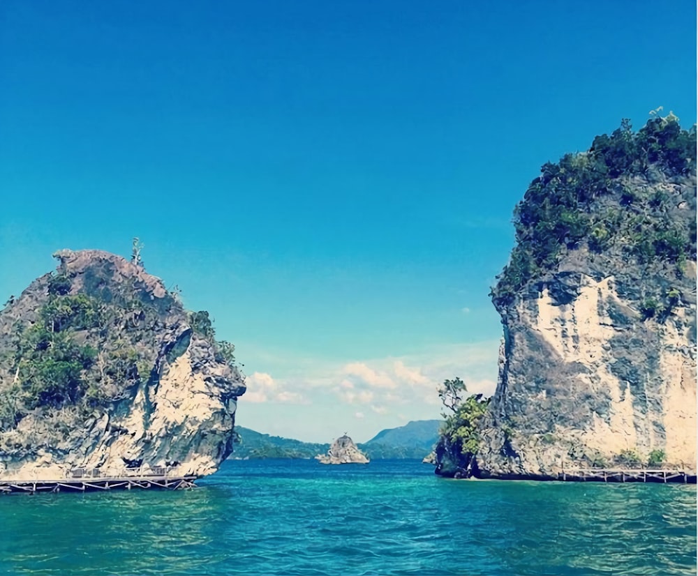 Formación rocosa marrón en el mar azul bajo el cielo azul durante el día