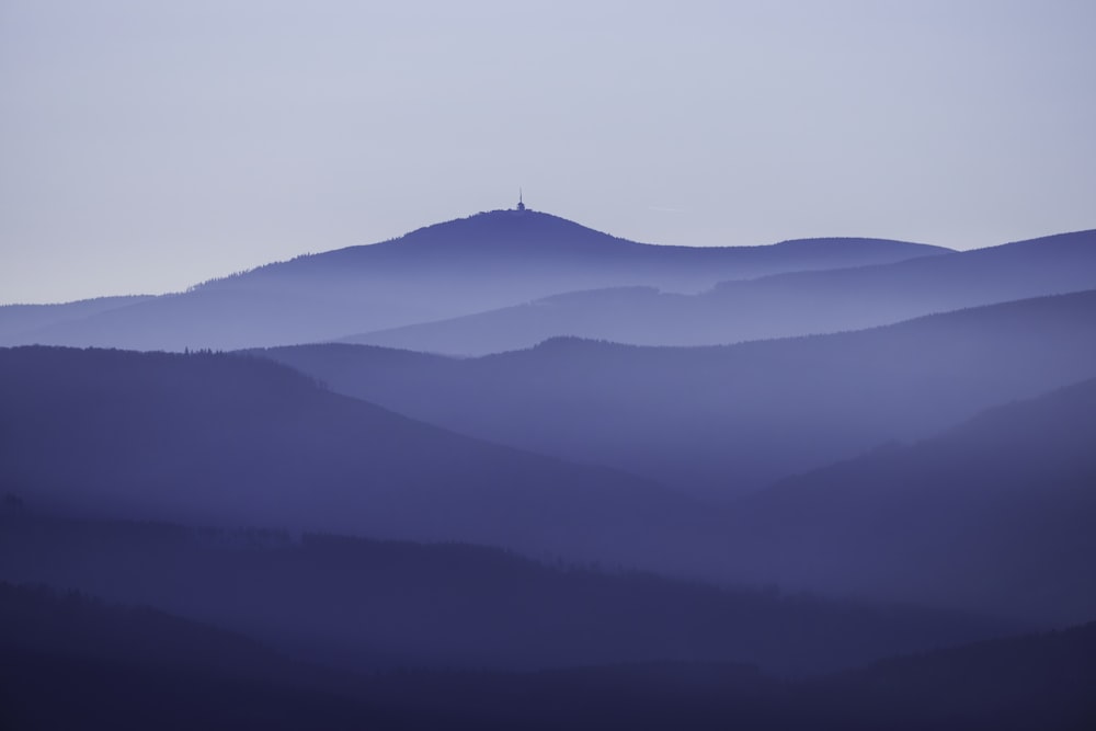 昼間の白い空の下の黒い山