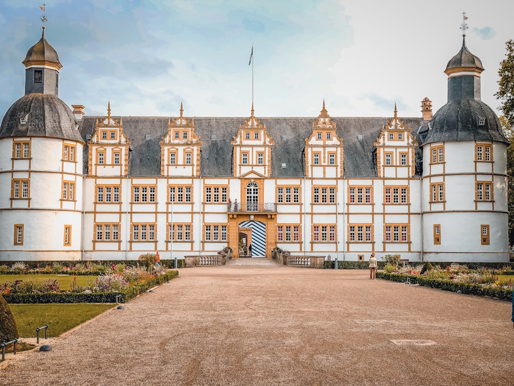 Bâtiment en béton blanc et brun sous des nuages blancs pendant la journée