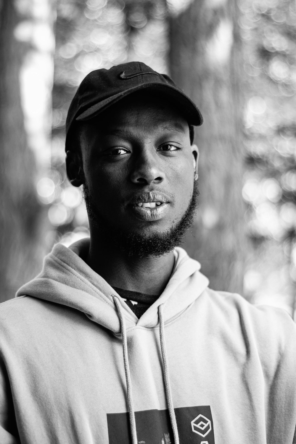 man in white hoodie wearing black cap