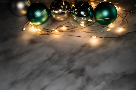 Stacked silver ornaments shimmering under soft lighting on a white marble surface