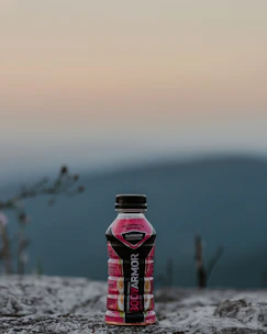 Hydration bottles and electrolyte mixes displayed outdoors with fresh mountain backdrop.