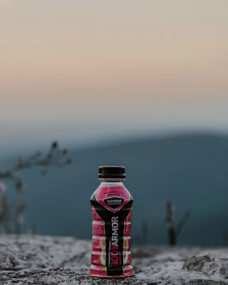 Hydration bottles and electrolyte mixes displayed outdoors with fresh mountain backdrop.