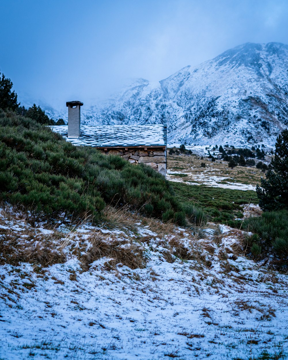 white and brown house near mountain under blue sky during daytime