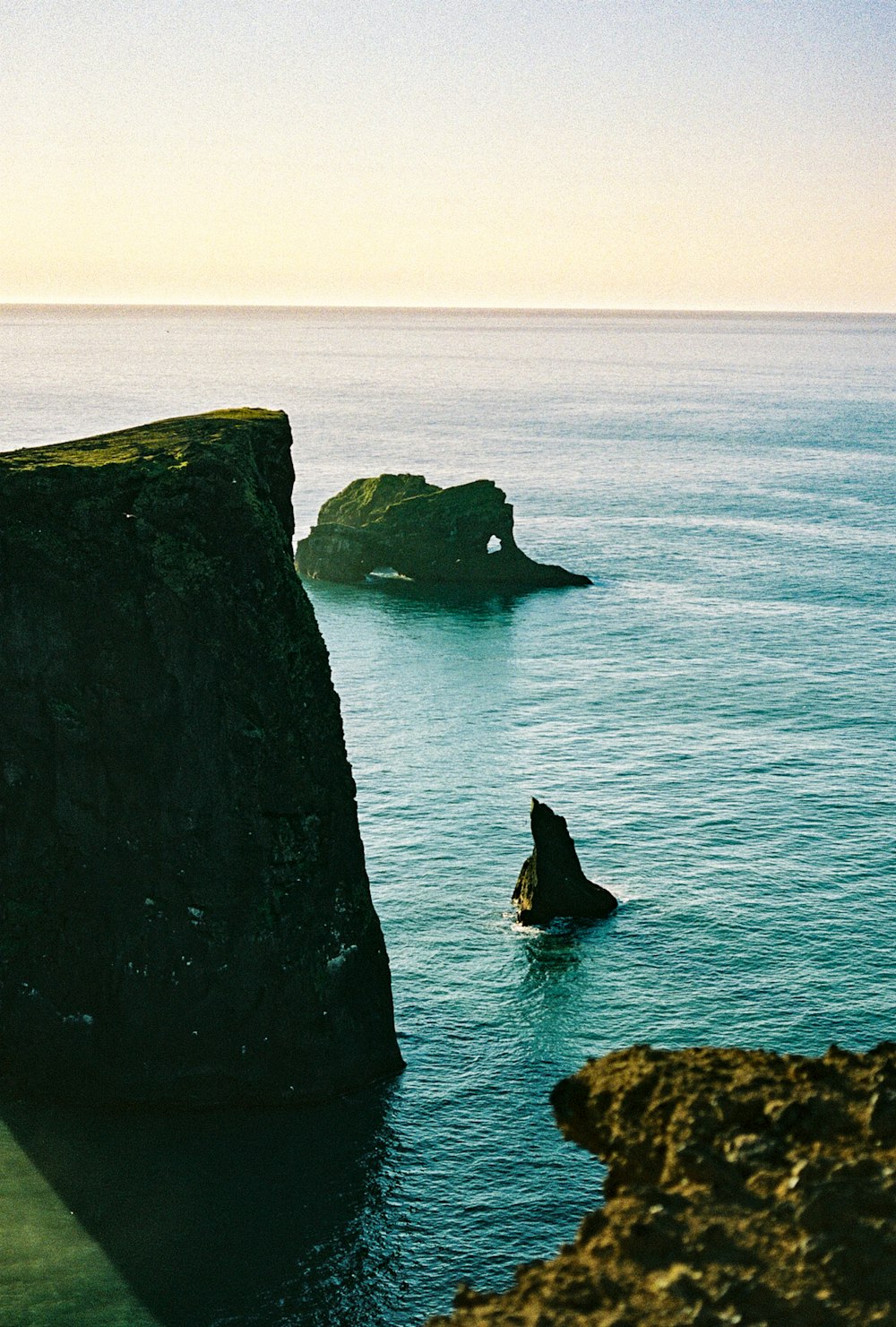 black rock formation on sea during daytime