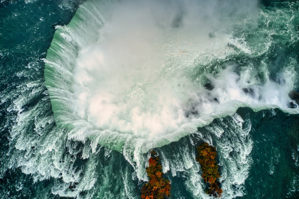 water waves hitting rocks during daytime