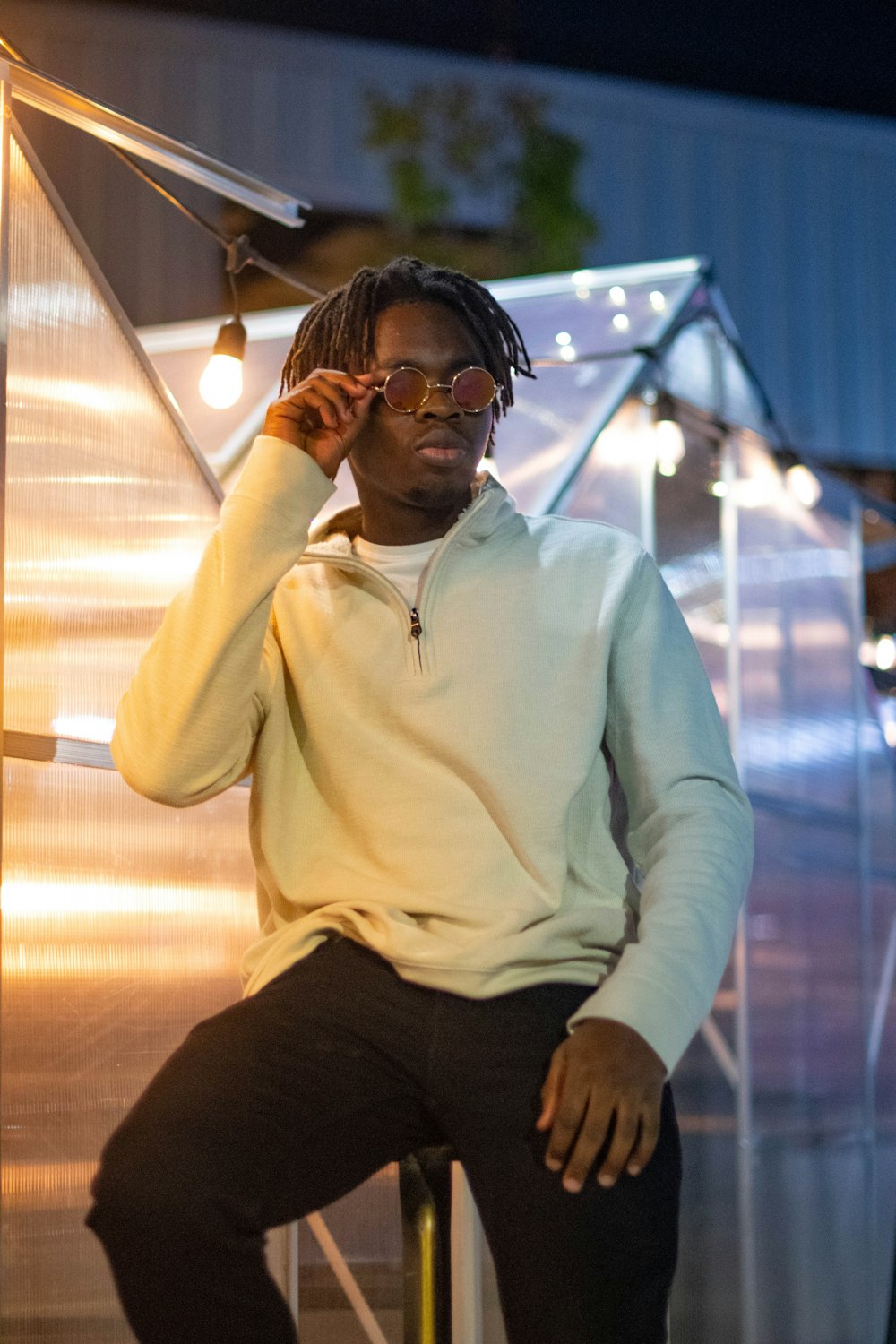 man in white sweater and black pants wearing black sunglasses