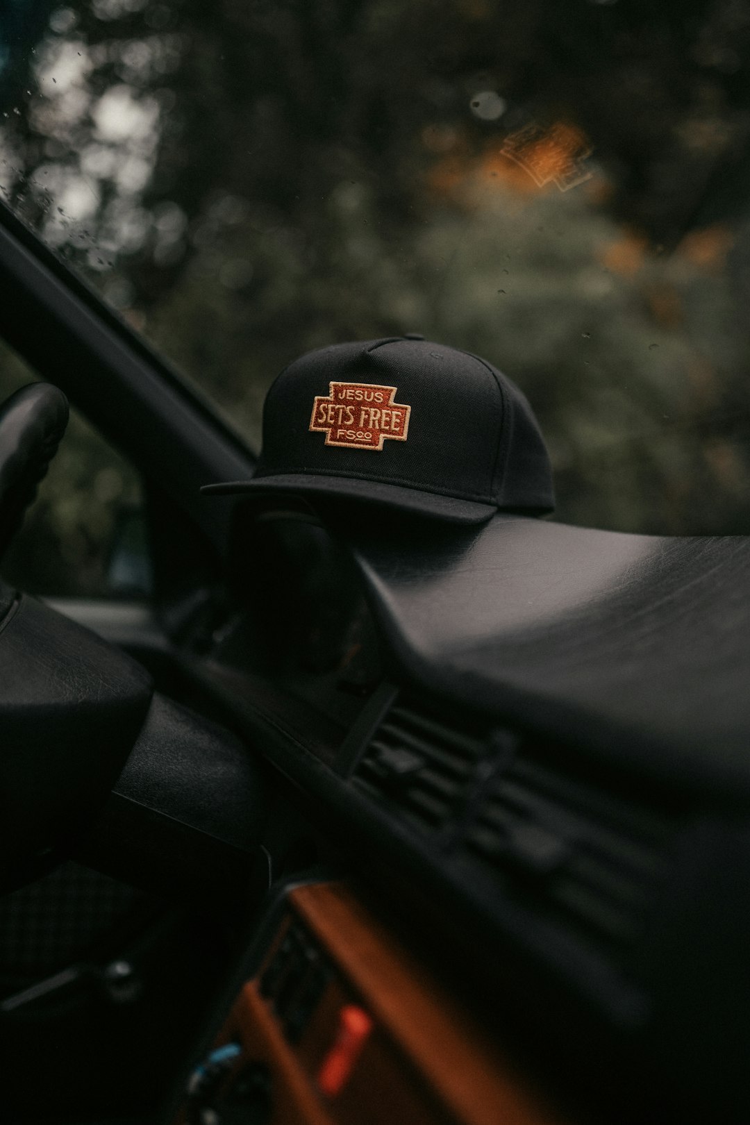 black and yellow fitted cap on black car steering wheel