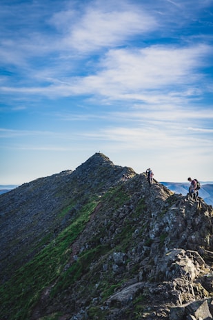 Hikers pausing on a mountain ridge, their shoes gripping the uneven terrain confidently.