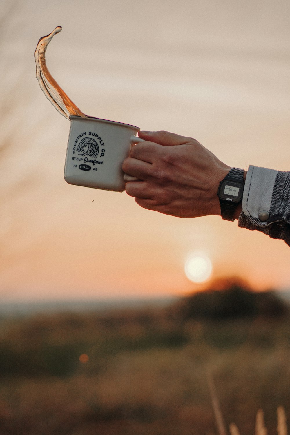 person holding white and black ceramic mug