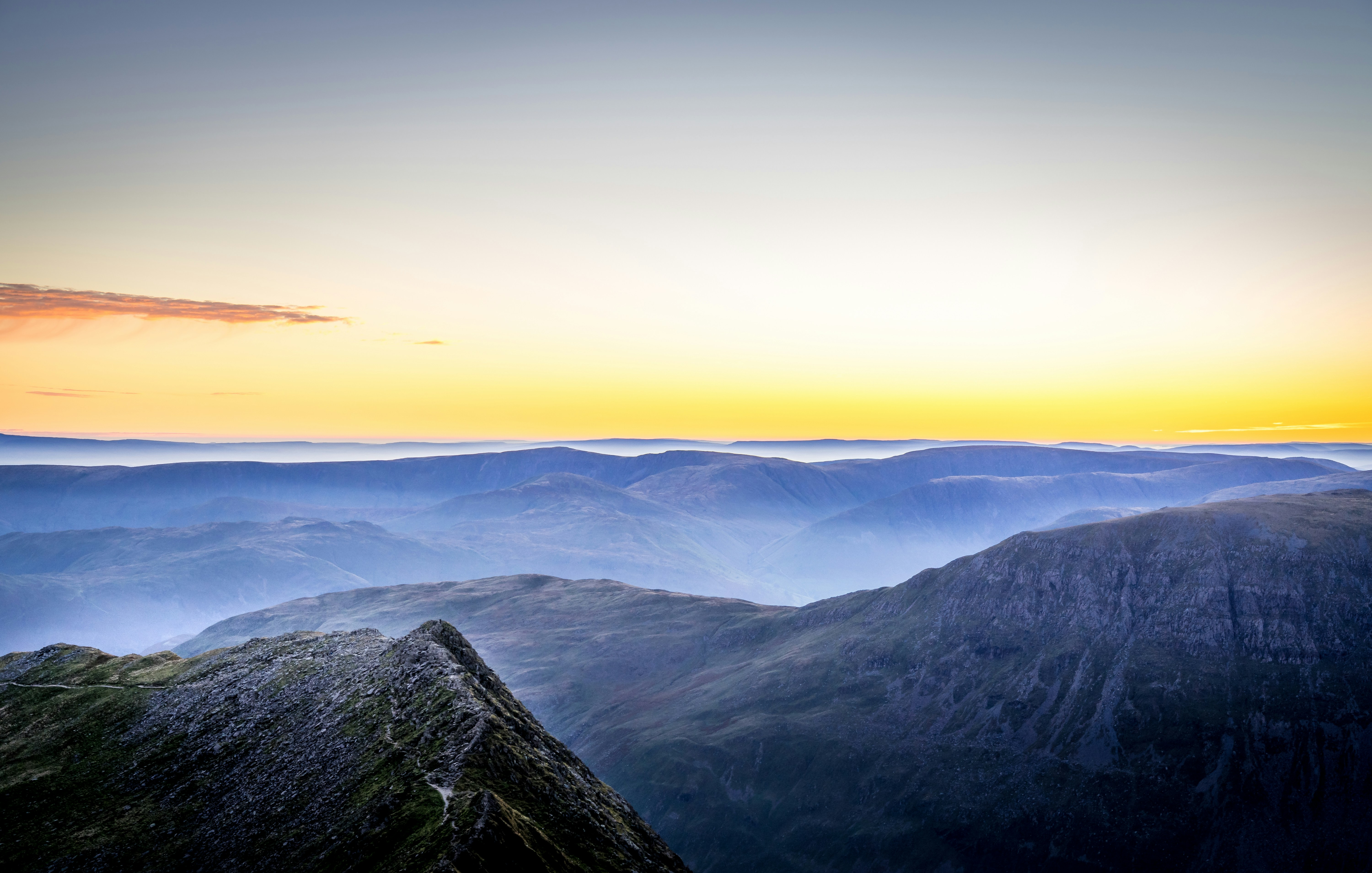 Grüner Berg tagsüber unter weißem Himmel