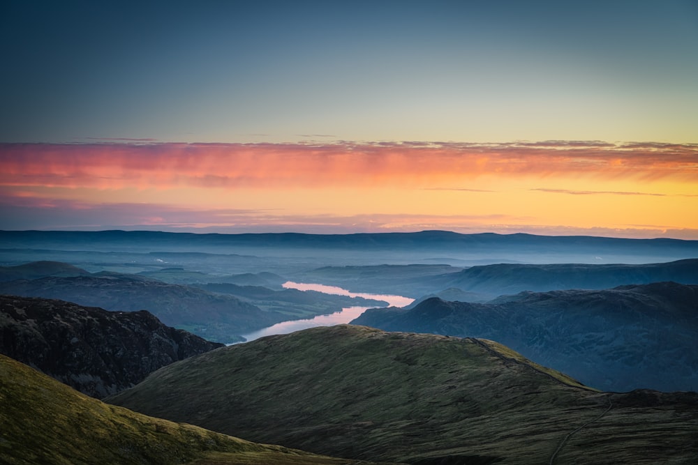 green mountains under orange sky