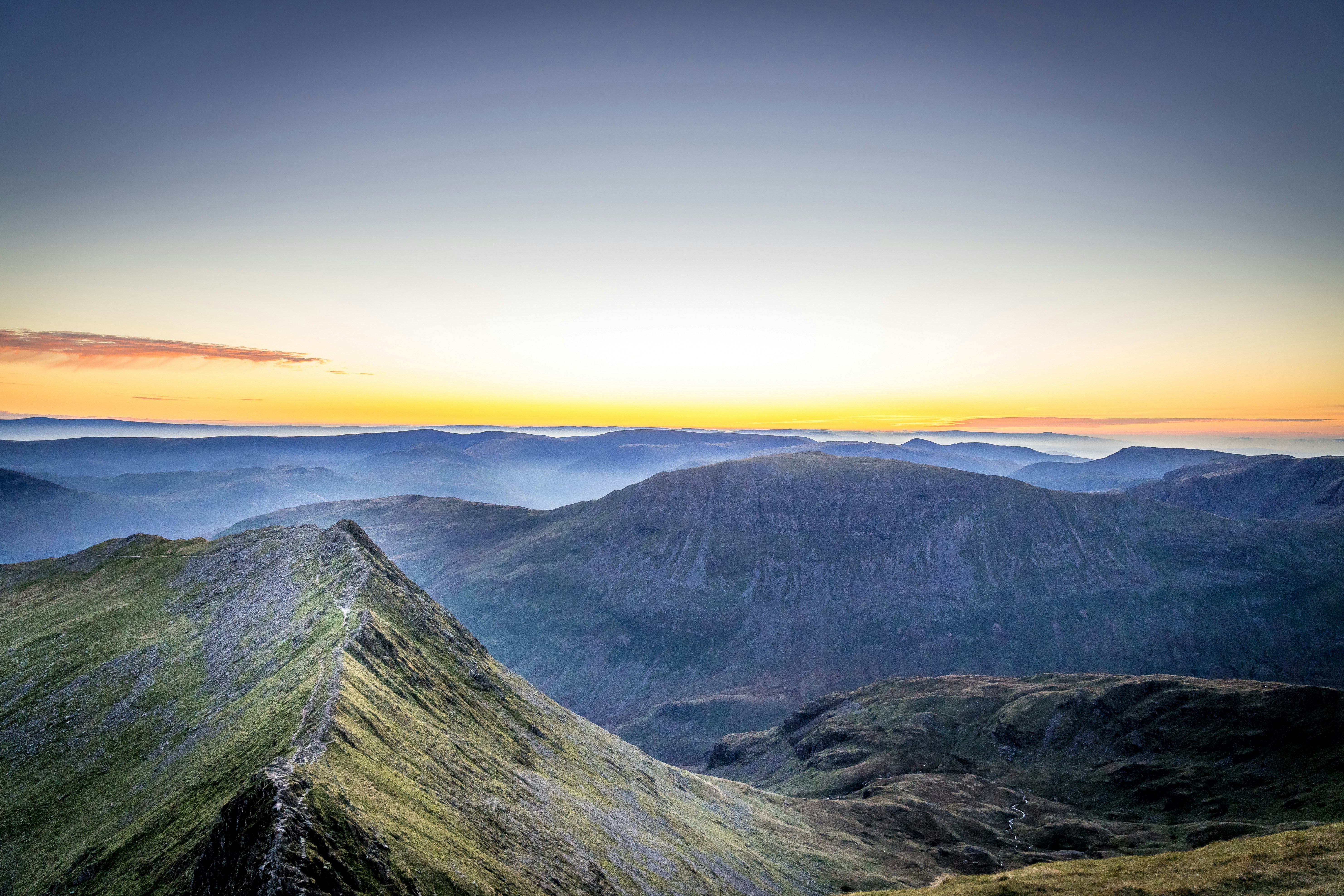 Grüner und schwarzer Berg tagsüber unter blauem Himmel