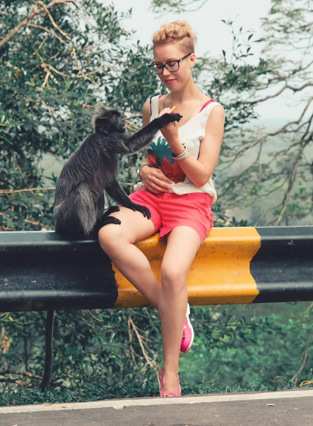 Femme en débardeur blanc assise sur un banc en bois marron