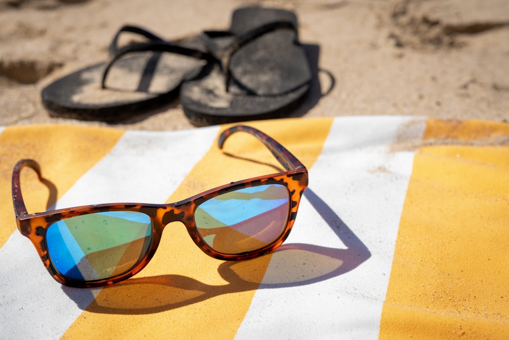 black framed sunglasses on white and brown textile