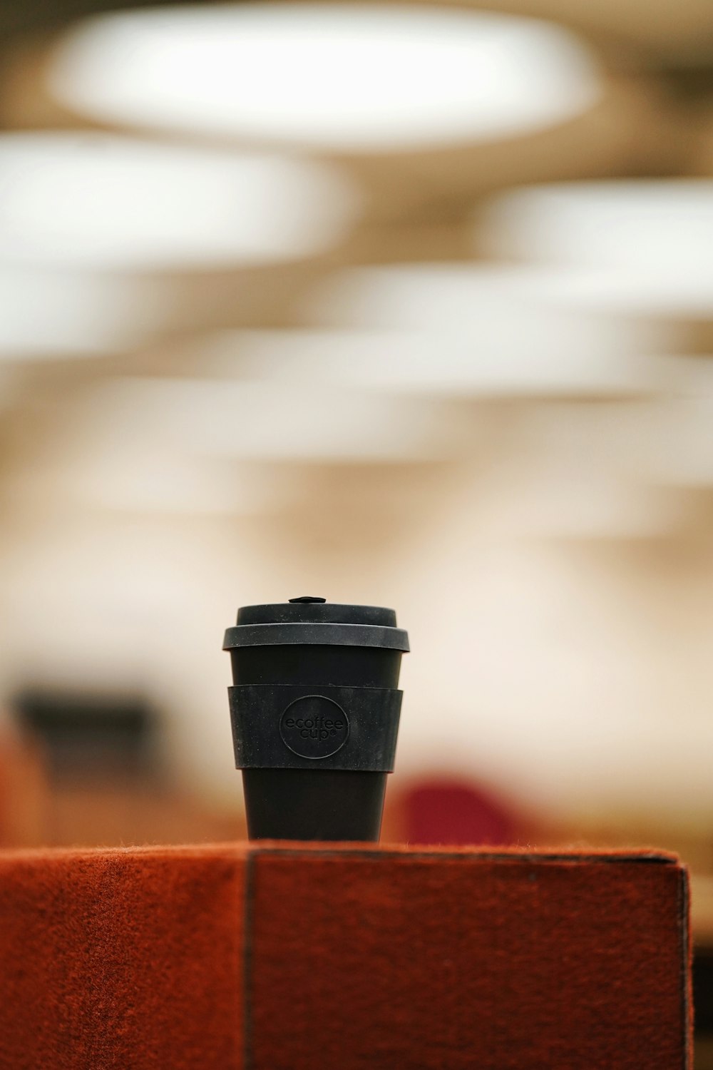 black and red plastic cup on brown wooden table
