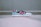 A pair of stylish athletic sneakers is placed on a flat surface. The sneakers feature a striking color combination of pastel blue, black, white, and vibrant pink. The design includes a sleek logo on the side and a textured sole.