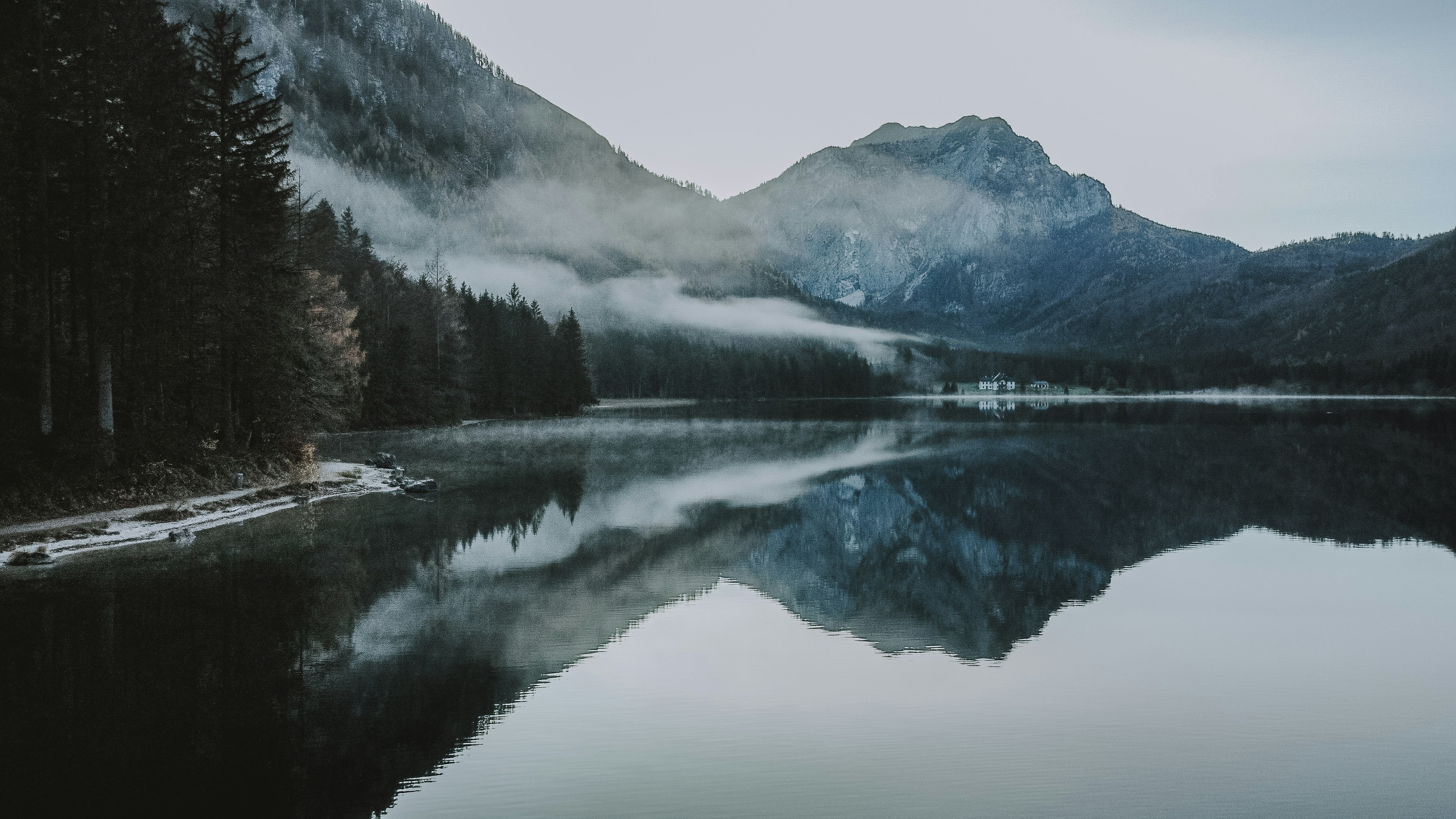 lake surrounded by trees and mountains during daytime