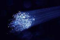A close-up of fiber optic cables glowing with light.