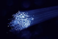 Close-up of fiber optic cables glowing with blue light.