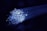 A cluster of glowing fiber optic cables emitting bright blue light against a dark background. The cables appear to be bundled together, with individual fibers visible, creating a starry effect as they disperse light.