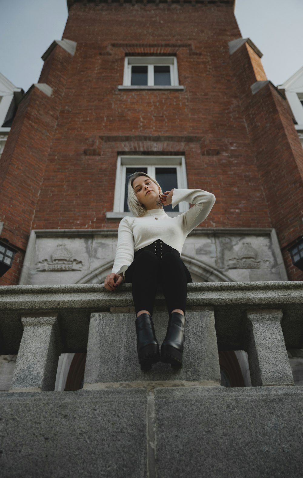 man in white shirt and black pants sitting on gray concrete stairs