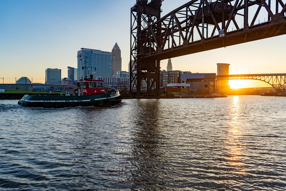 red and black boat on water near bridge during daytime