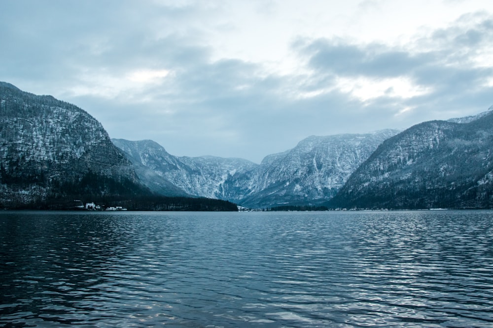 body of water near mountain during daytime