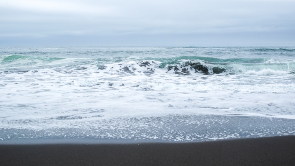 ocean waves crashing on shore during daytime