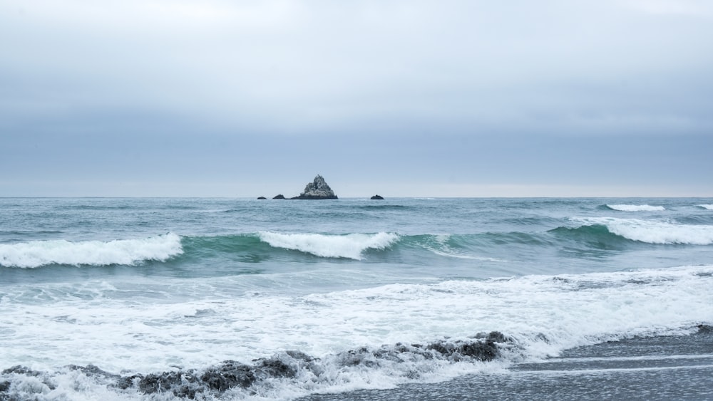 ocean waves crashing on shore during daytime