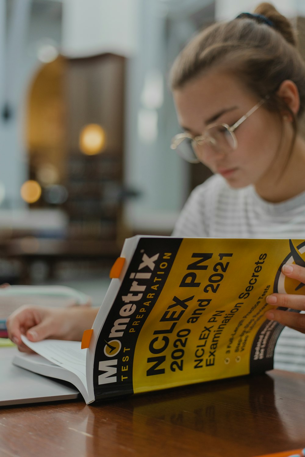 woman in white crew neck shirt holding yellow and black labeled box