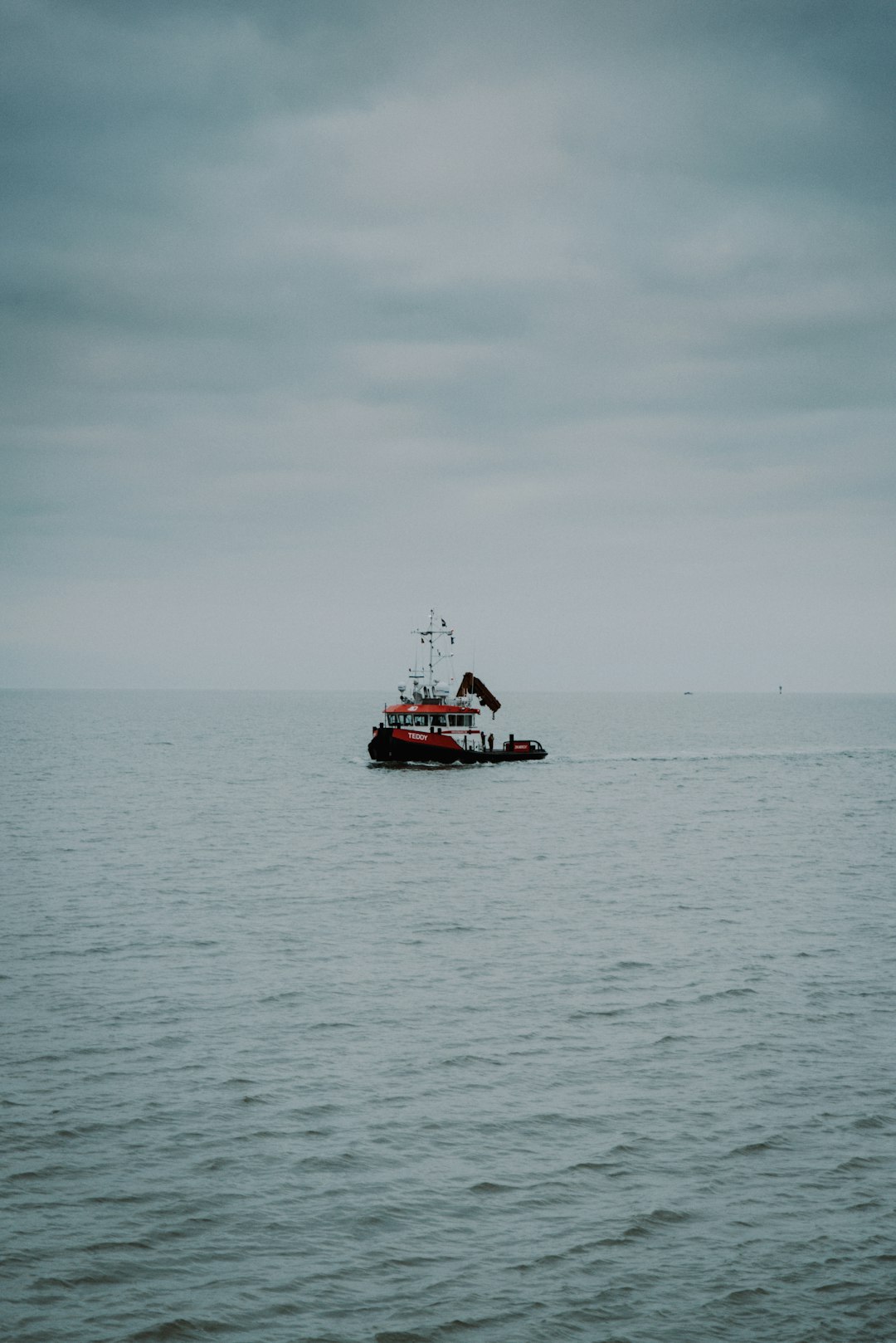 red and white boat on sea under white sky during daytime