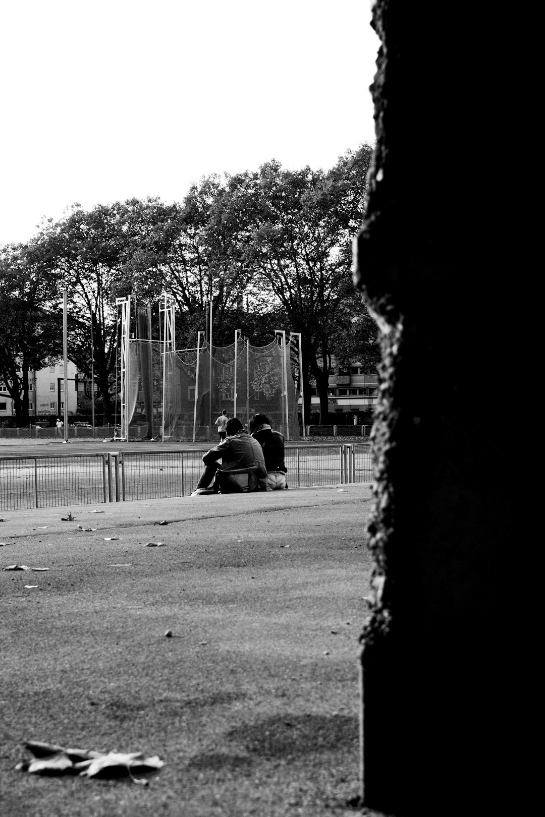 grayscale photo of 2 people sitting on bench