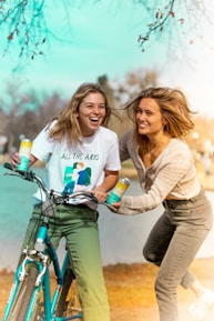 A cheerful client and support worker sharing a laugh while out for a walk in a park.