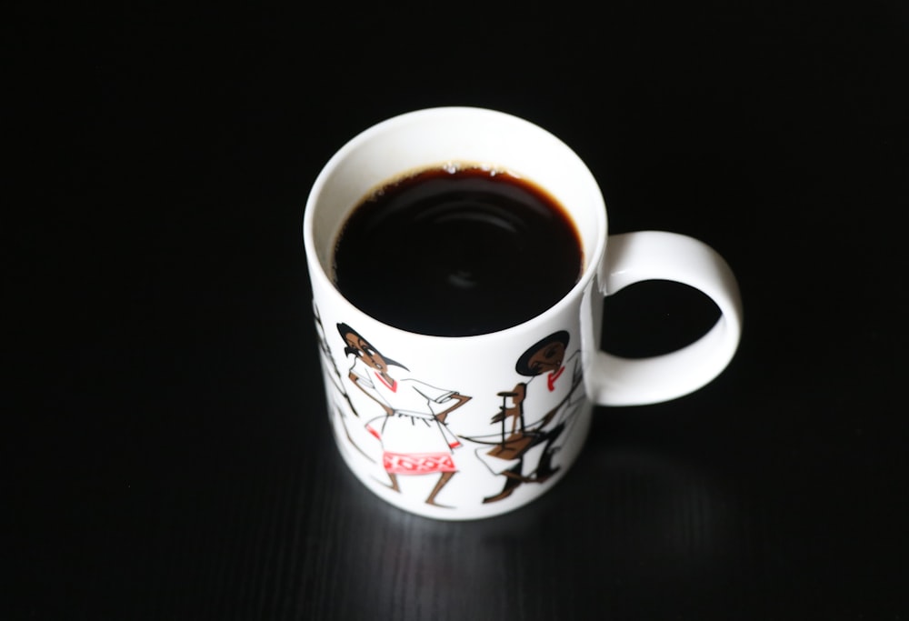 white and red ceramic mug with black liquid