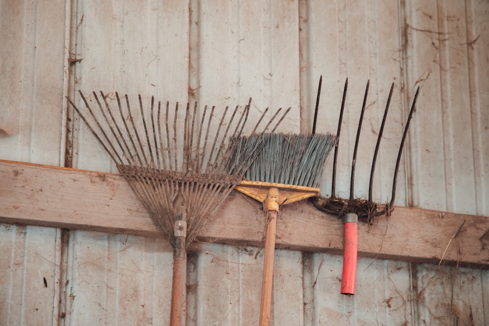 brown broom stick leaning on white wall