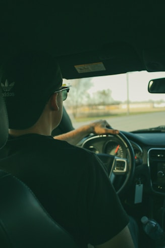 man in black shirt driving car during daytime