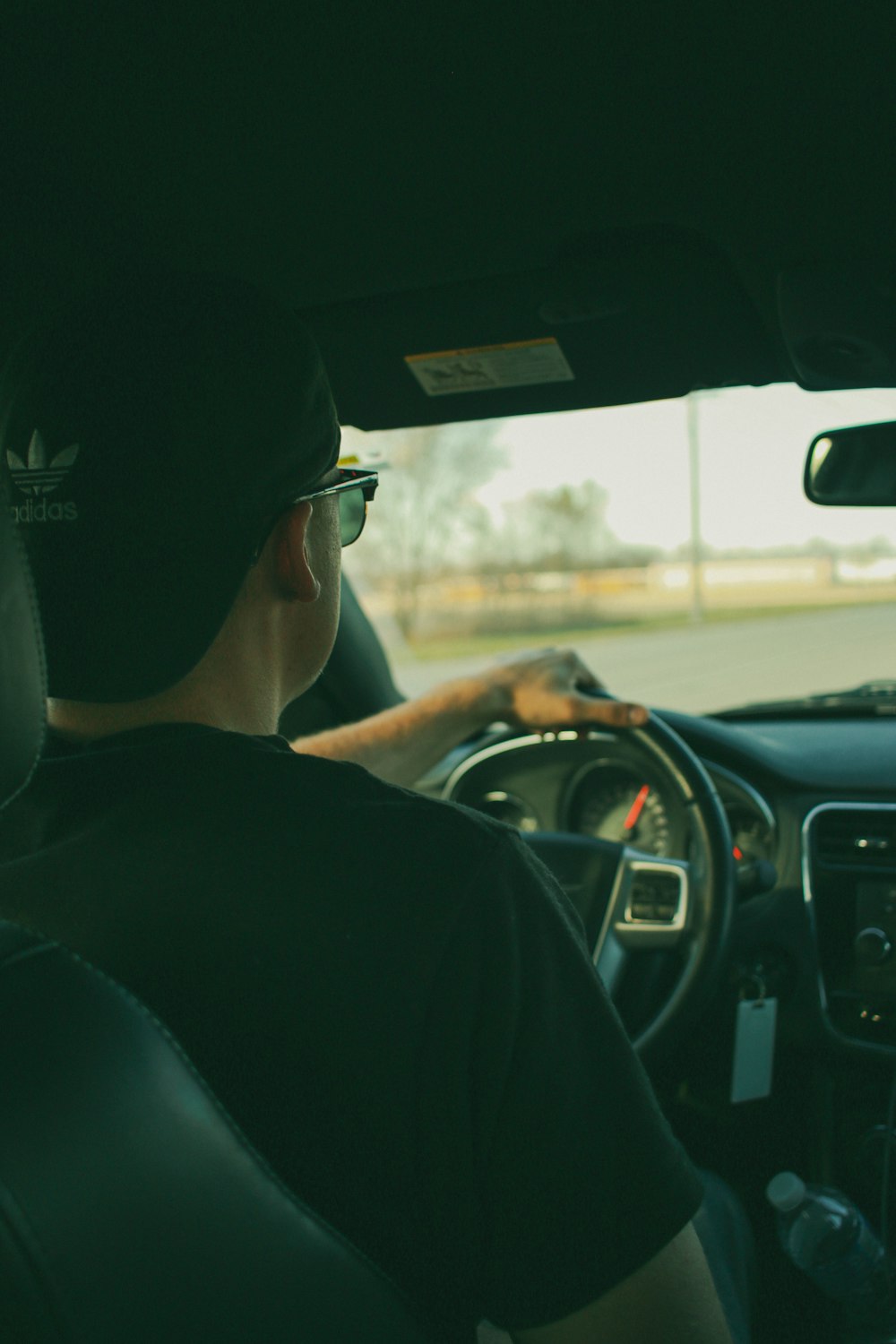 man in black shirt driving car during daytime
